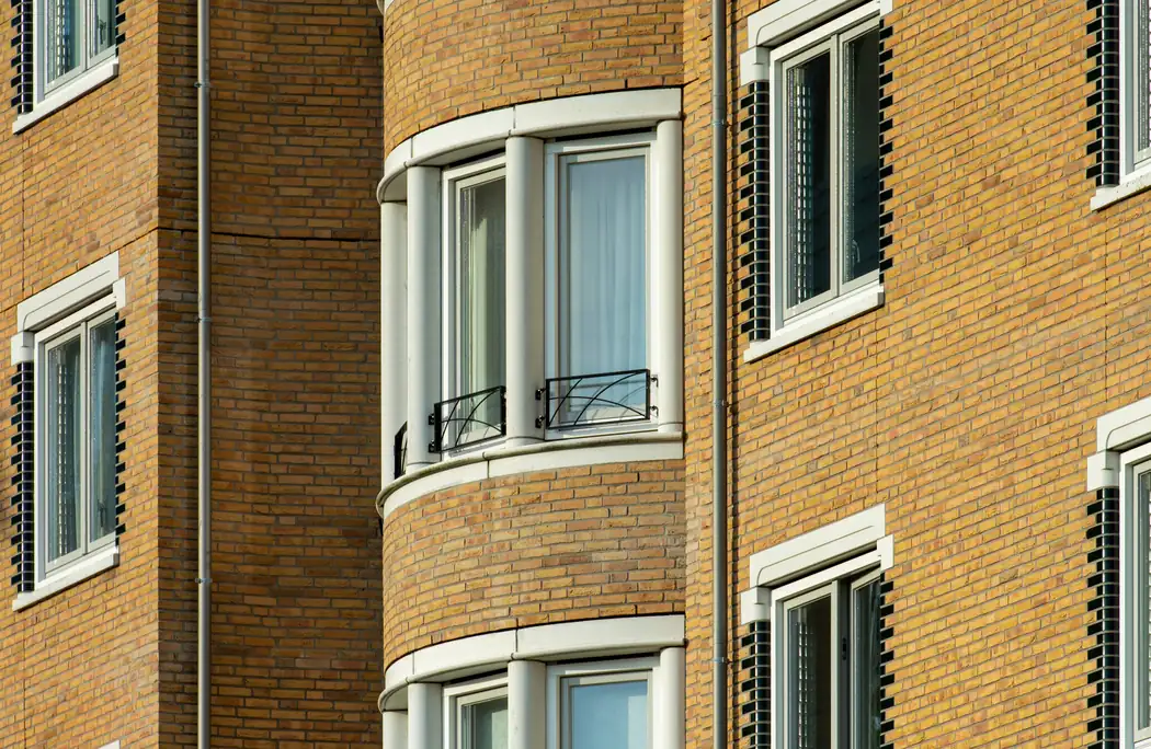 Bakstenen portiekflat met erkers, het pandtype waar deze diensten over gaan